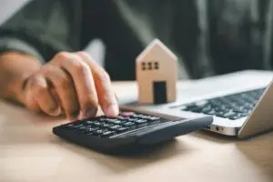 a person using a calculator to calculate the cost of a house
